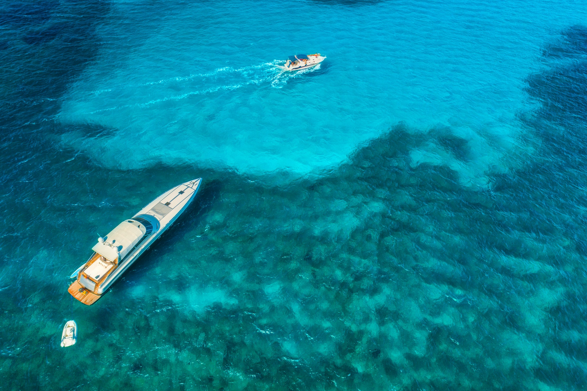 Aerial view of luxury yachts in transparent blue sea